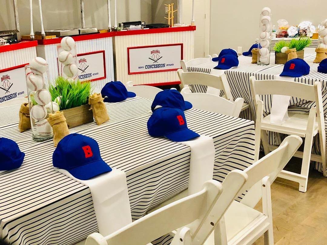 Baseball themed party tables with blue caps, baseball centerpieces, and concession stands.