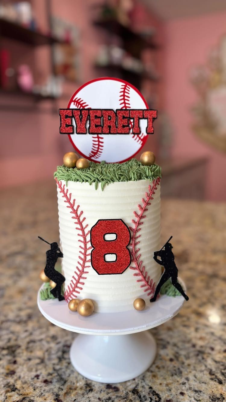 Baseball themed cake with red stitching, number 8, and baseball player silhouettes.