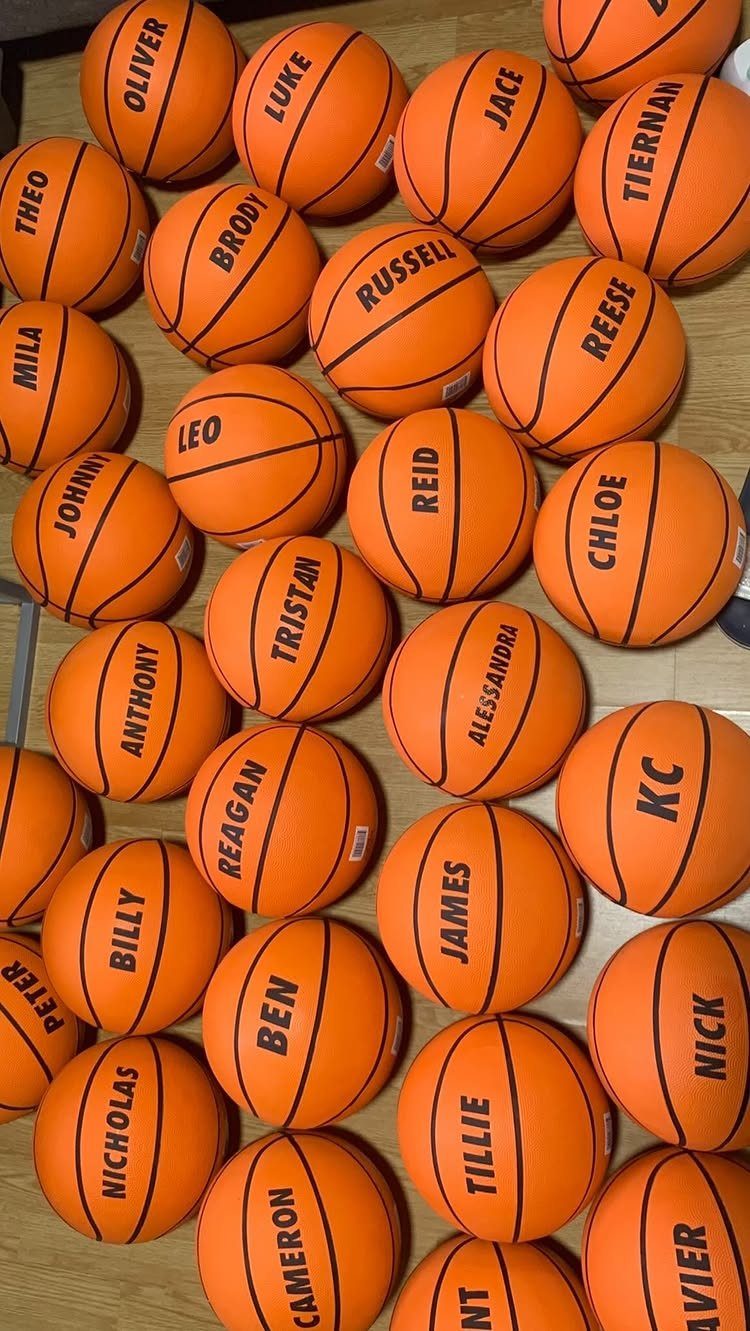 Personalized orange basketballs with names printed on them for a party favor.