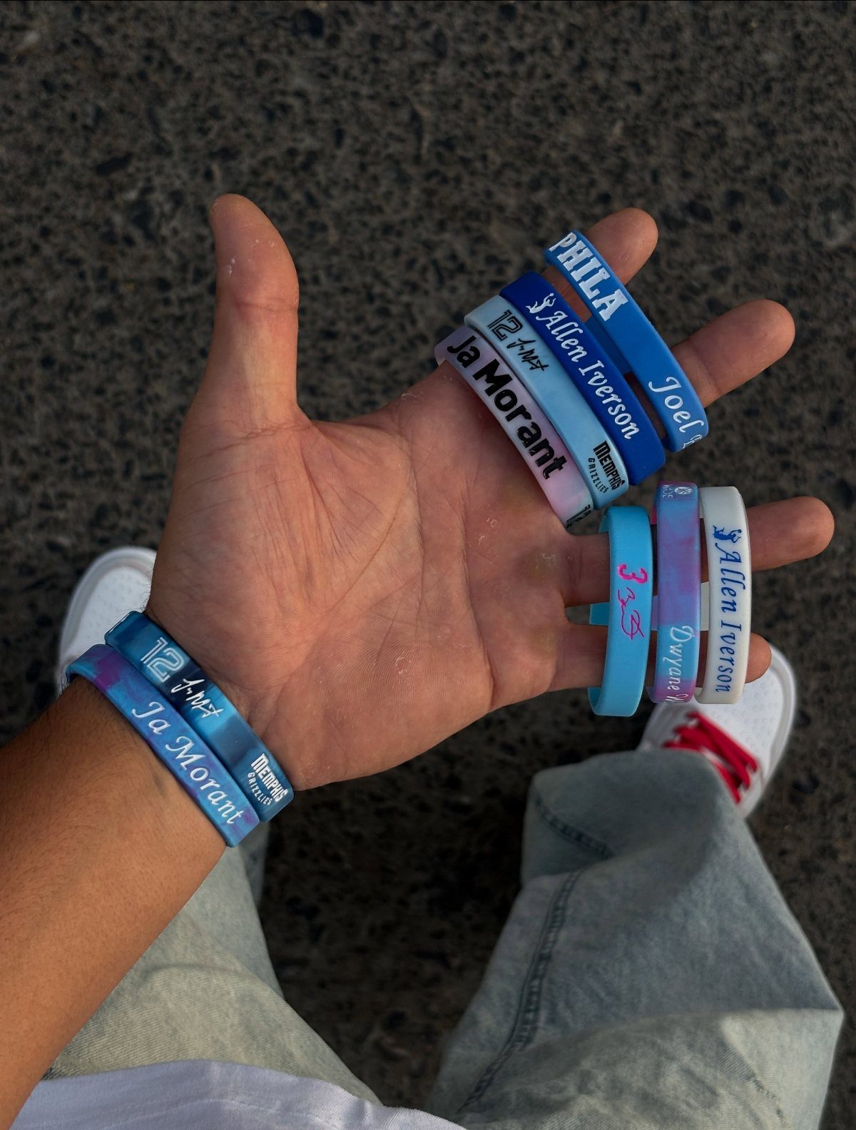Silicone basketball player wristbands held in a hand and worn on a wrist.
