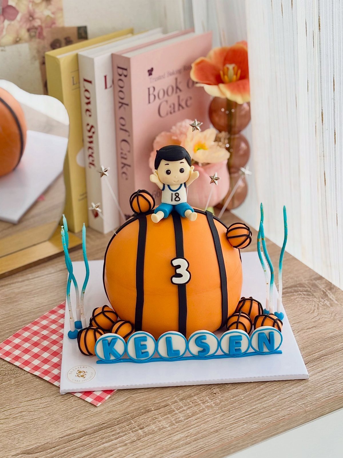 Basketball shaped cake with a small player figure and name KELSEN on base
