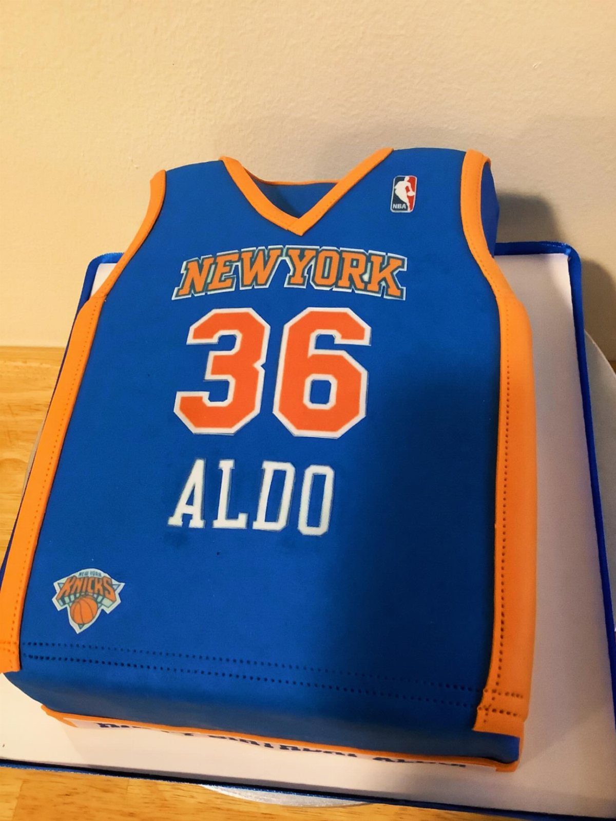Basketball jersey cake in blue and orange with the name Aldo and number 36.