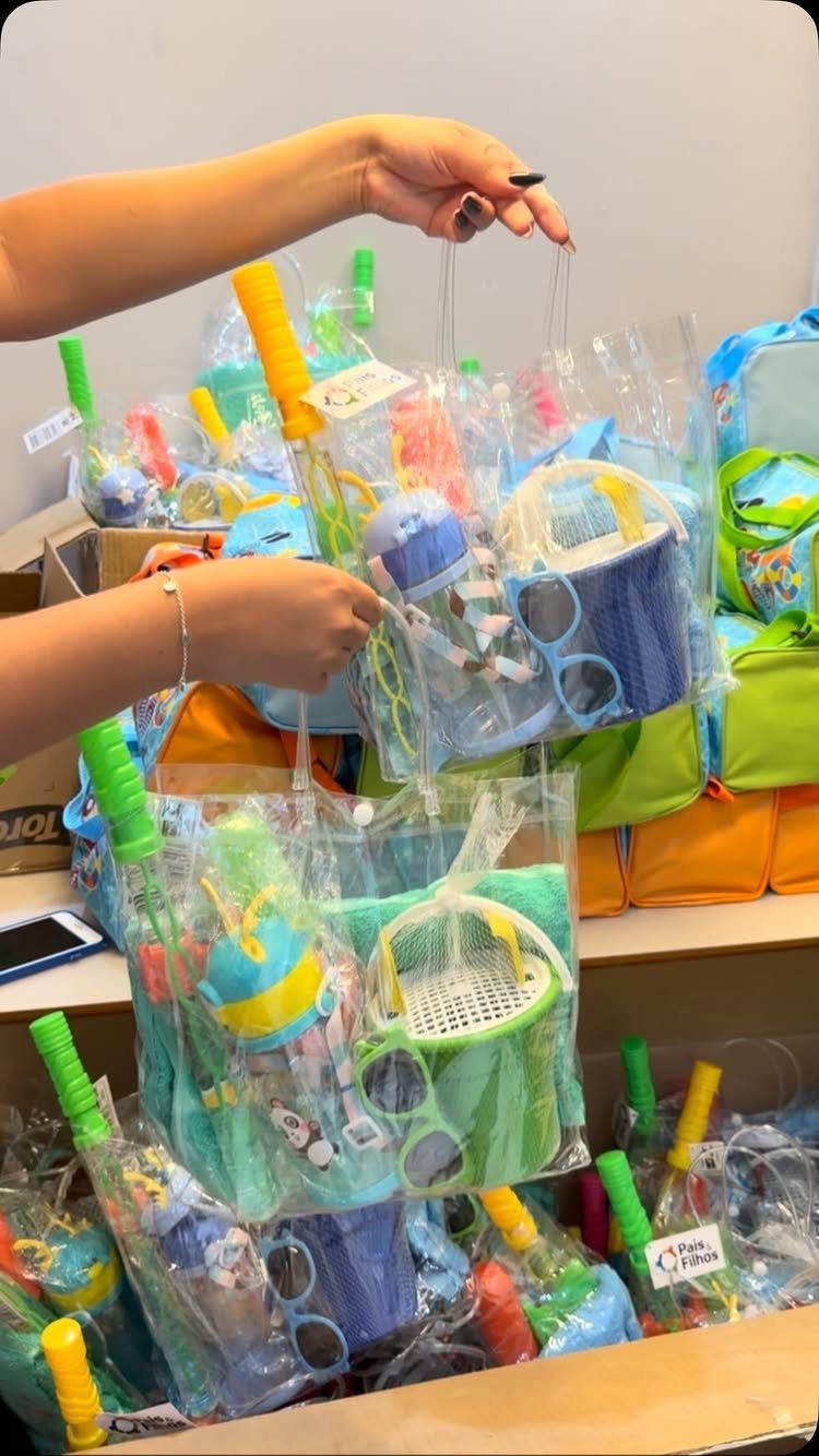 Clear plastic tote bags filled with colorful beach toys and accessories for a party.