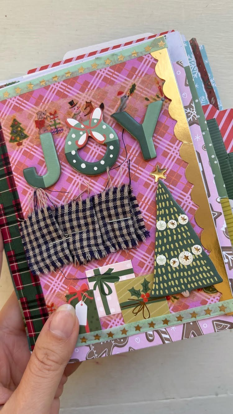 Handmade holiday scrapbook page with JOY lettering, a Christmas tree, and festive patterns.