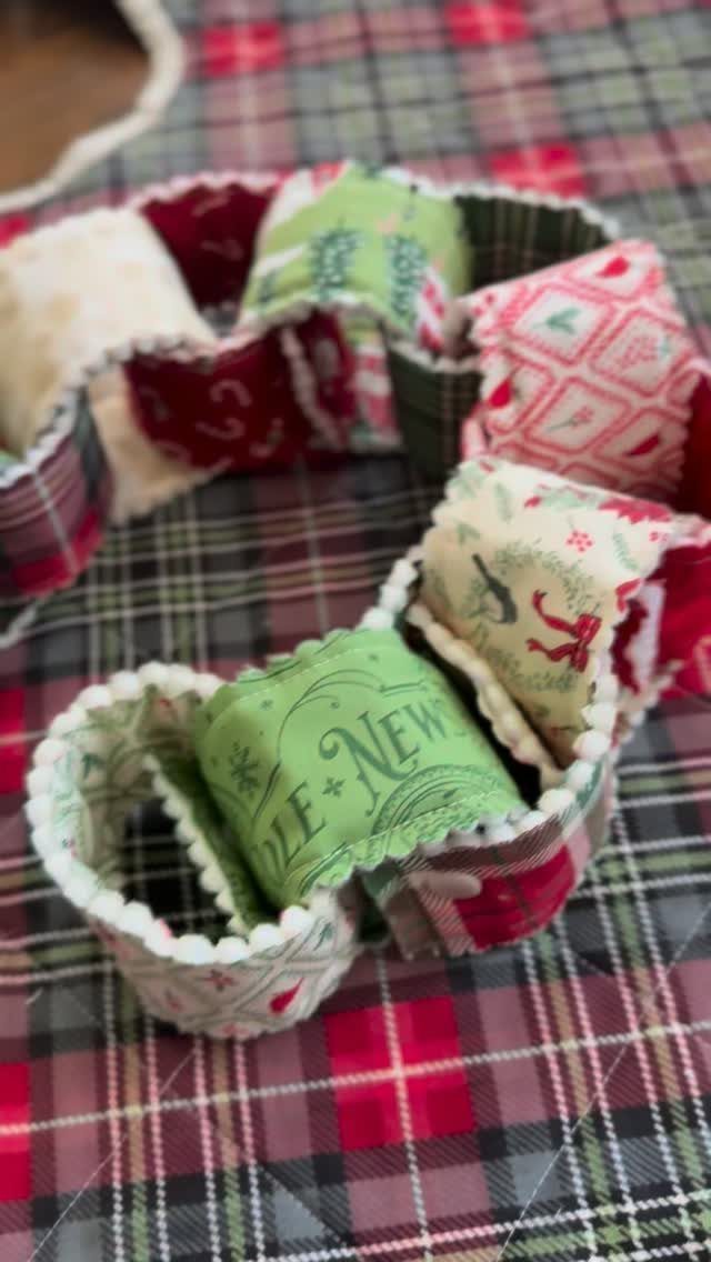 Fabric chain with red and green holiday patterns on a plaid background