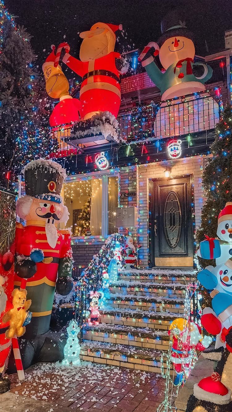Christmas house decorations with large inflatable nutcracker and Santa figures and colorful lights.