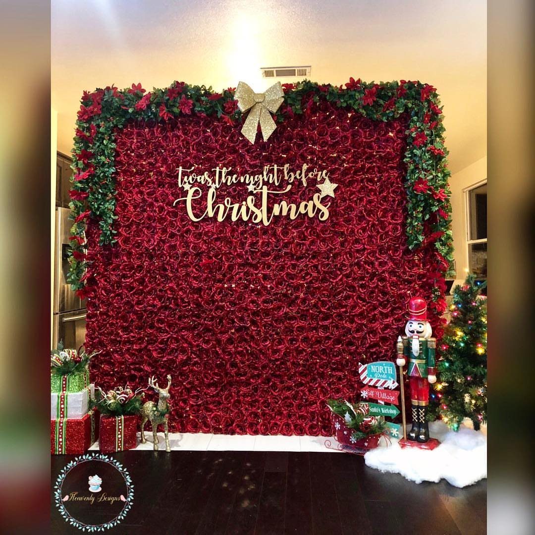 Red rose wall backdrop with Christmas decorations, gold signage, and a nutcracker figure.