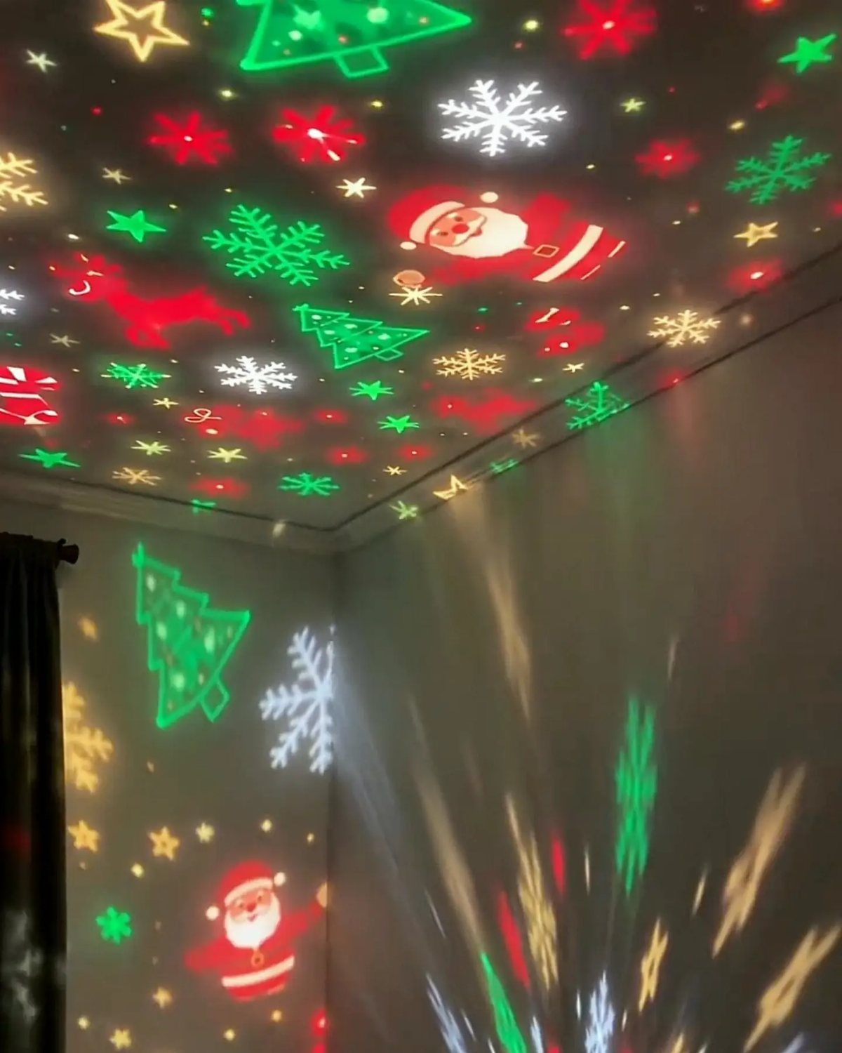Christmas themed light projections of Santa, trees, and snowflakes on a room ceiling