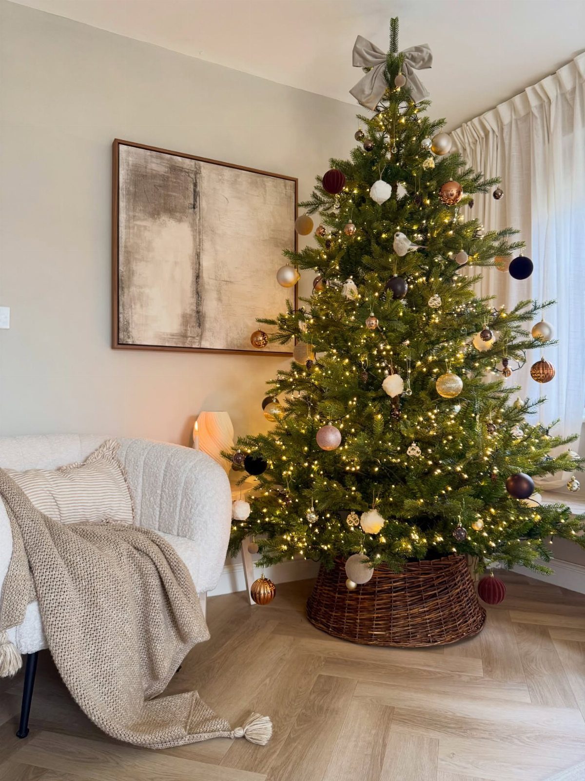 Decorated Christmas tree with warm white fairy lights in a cozy living room.