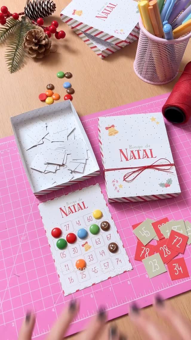 Christmas bingo card with colorful candy markers and numbered tiles on pink mat