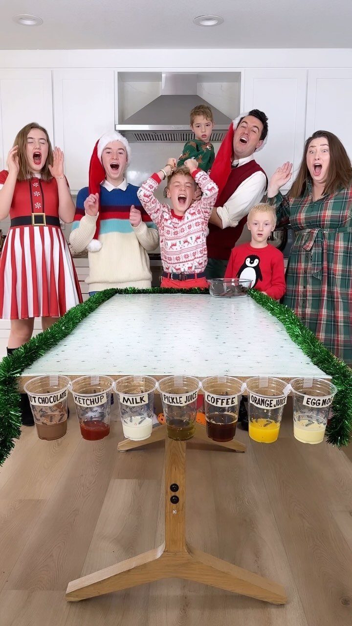 Group of people in Christmas clothes standing behind a taste test activity table.