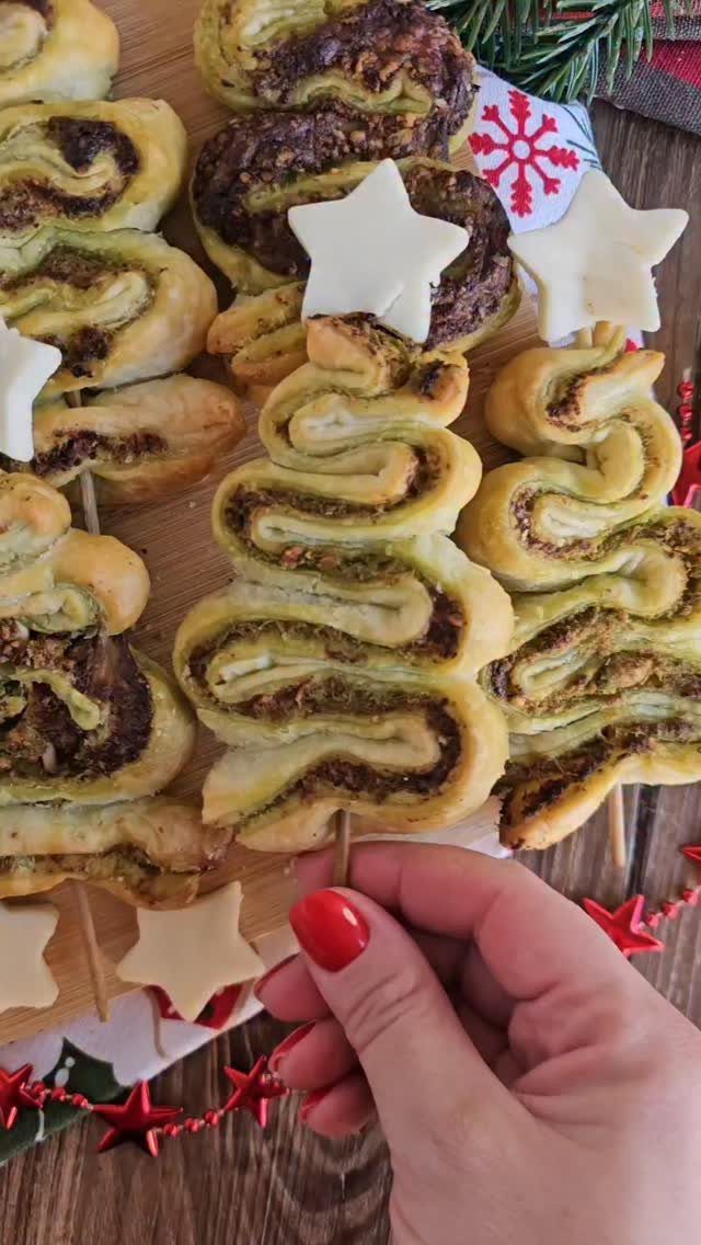 Pesto puff pastry pinwheels shaped like Christmas trees with white star toppers.