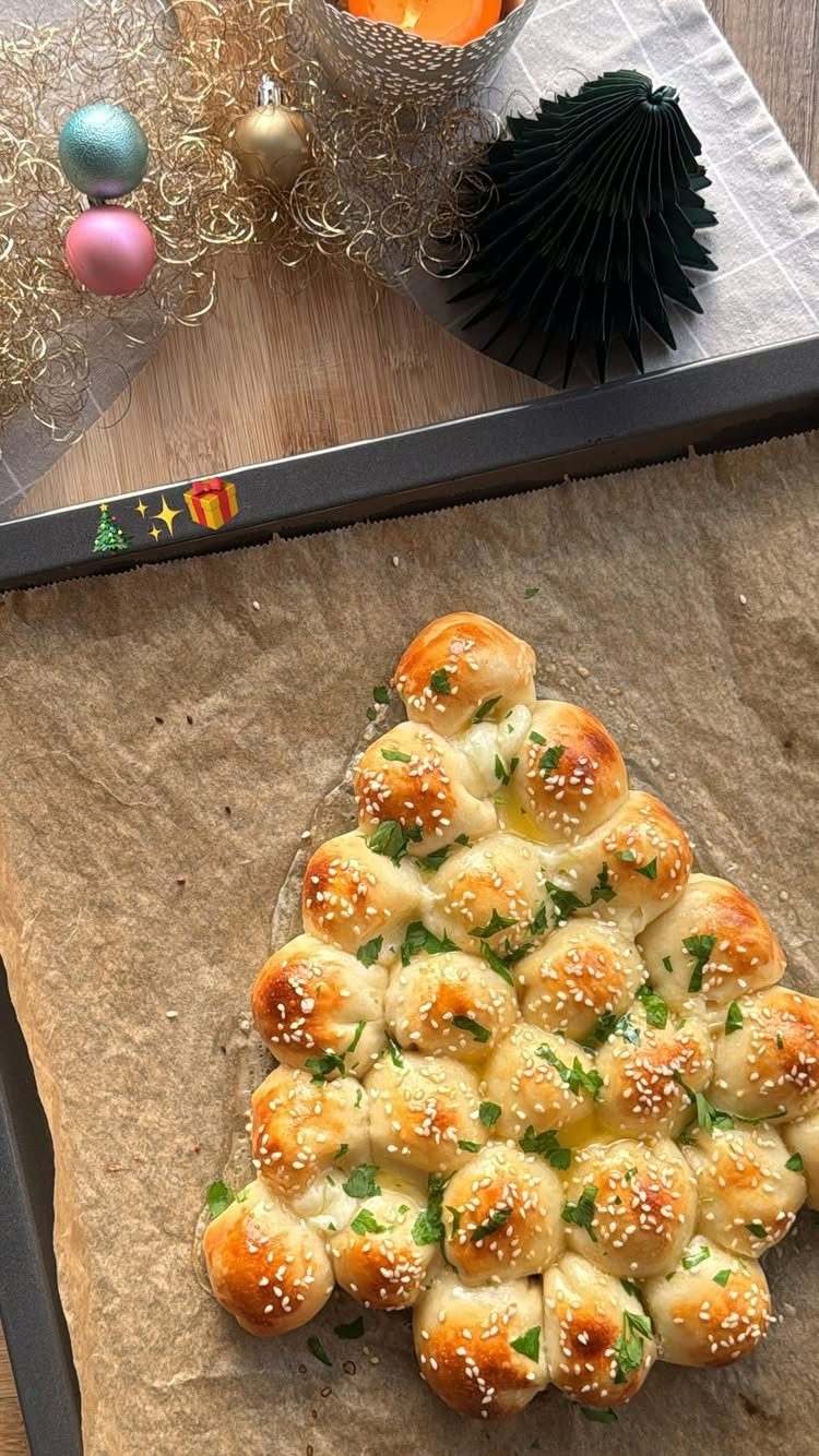 Pull-apart bread shaped like a Christmas tree topped with sesame seeds and parsley.