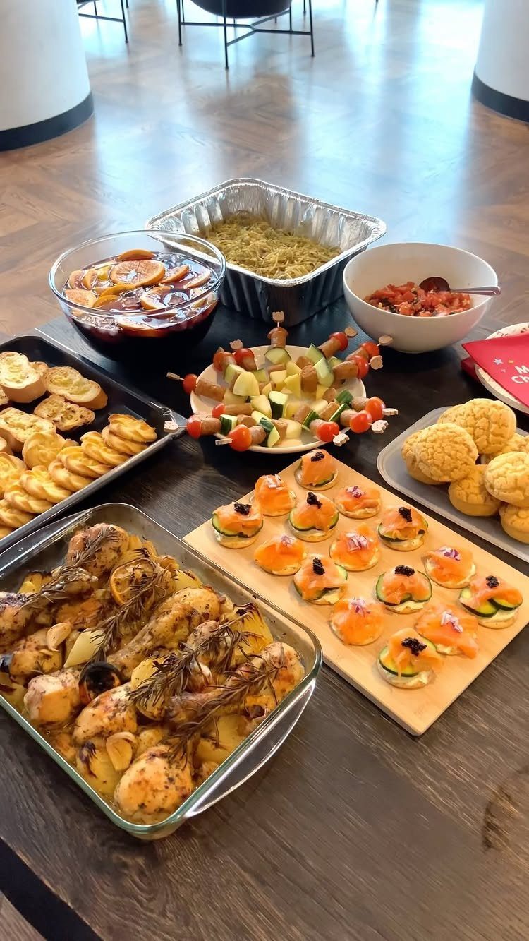 Assorted party appetizers and sangria spread across a dark wooden dining table.