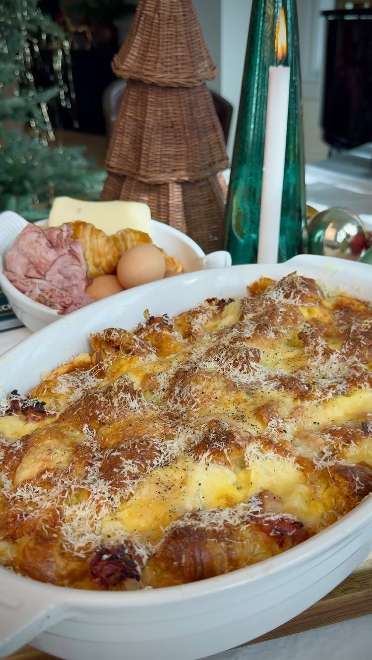 Savory breakfast casserole in a white dish with brunch sides and Christmas decorations.