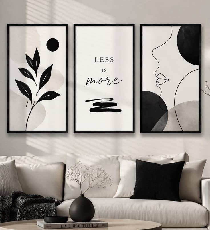 Three minimalist black and white art prints hanging above a modern white sofa.