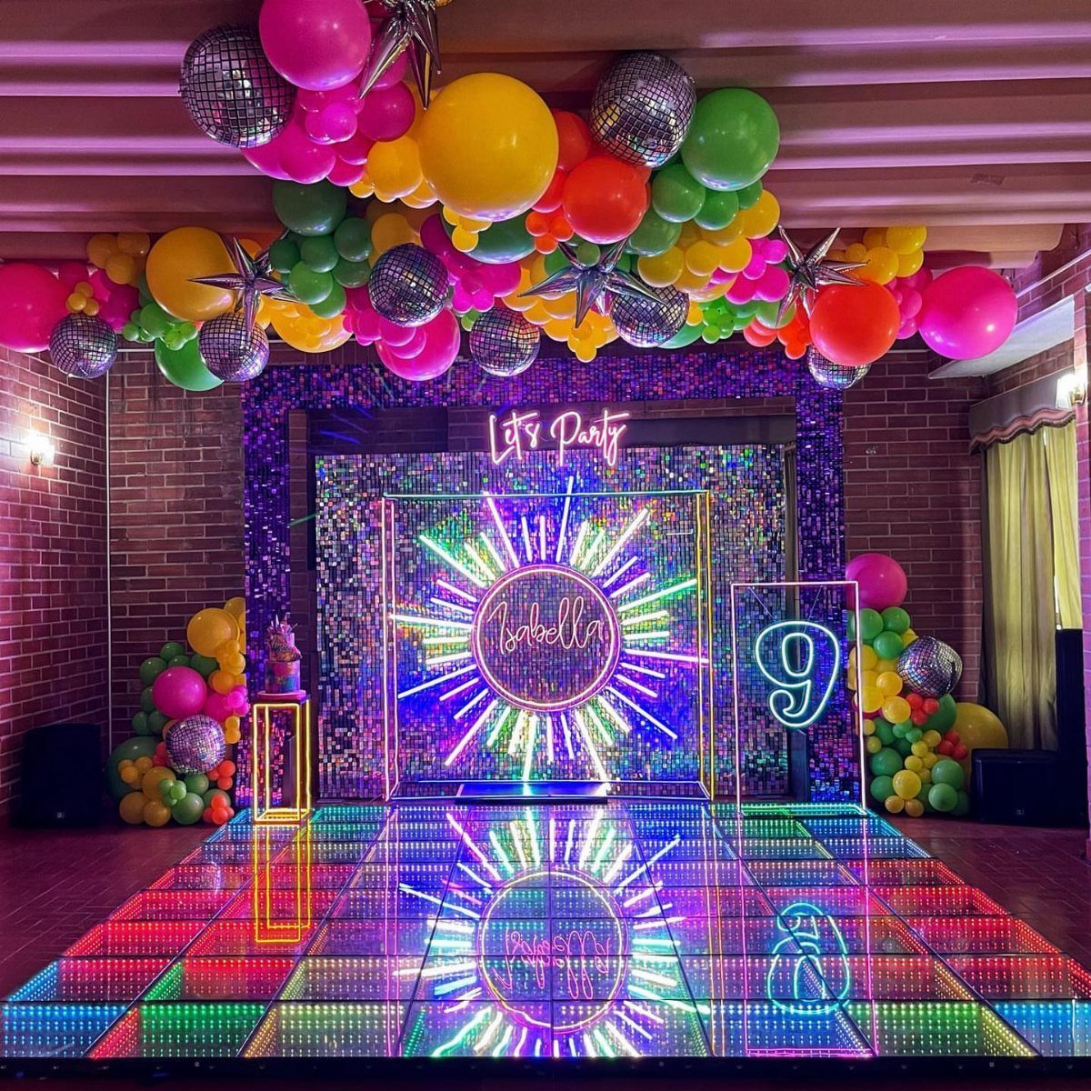 Vibrant party setup with neon lights, colorful balloons, and a glowing LED dance floor.