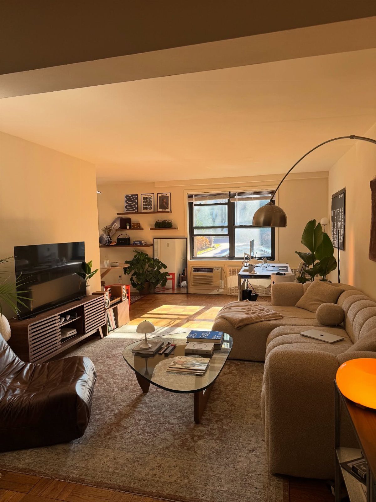 Living room with beige sectional sofa, leather chair, and large neutral area rug.