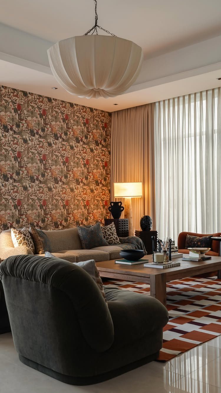 Living room with floral wallpaper, geometric rug, and brown furniture in warm tones.