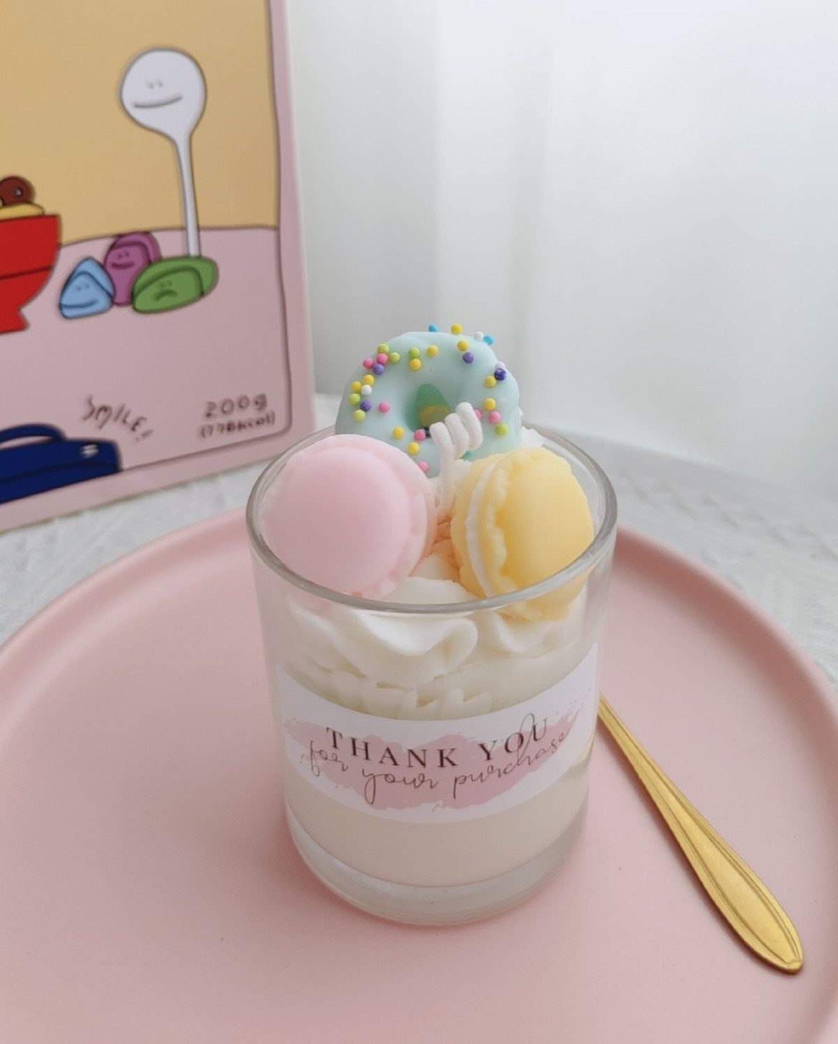 Dessert cup with macarons and a mini donut on a pink plate
