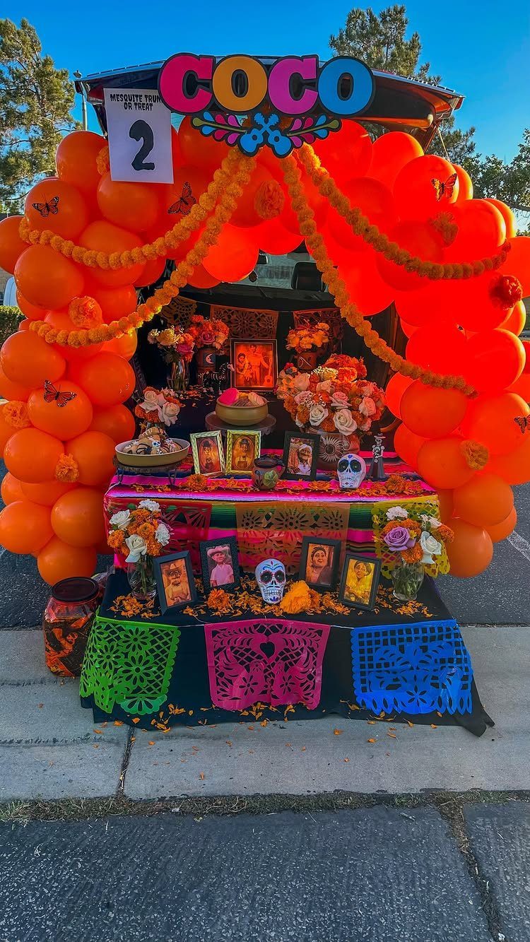 Coco themed trunk or treat display with orange balloons and Day of the Dead decor