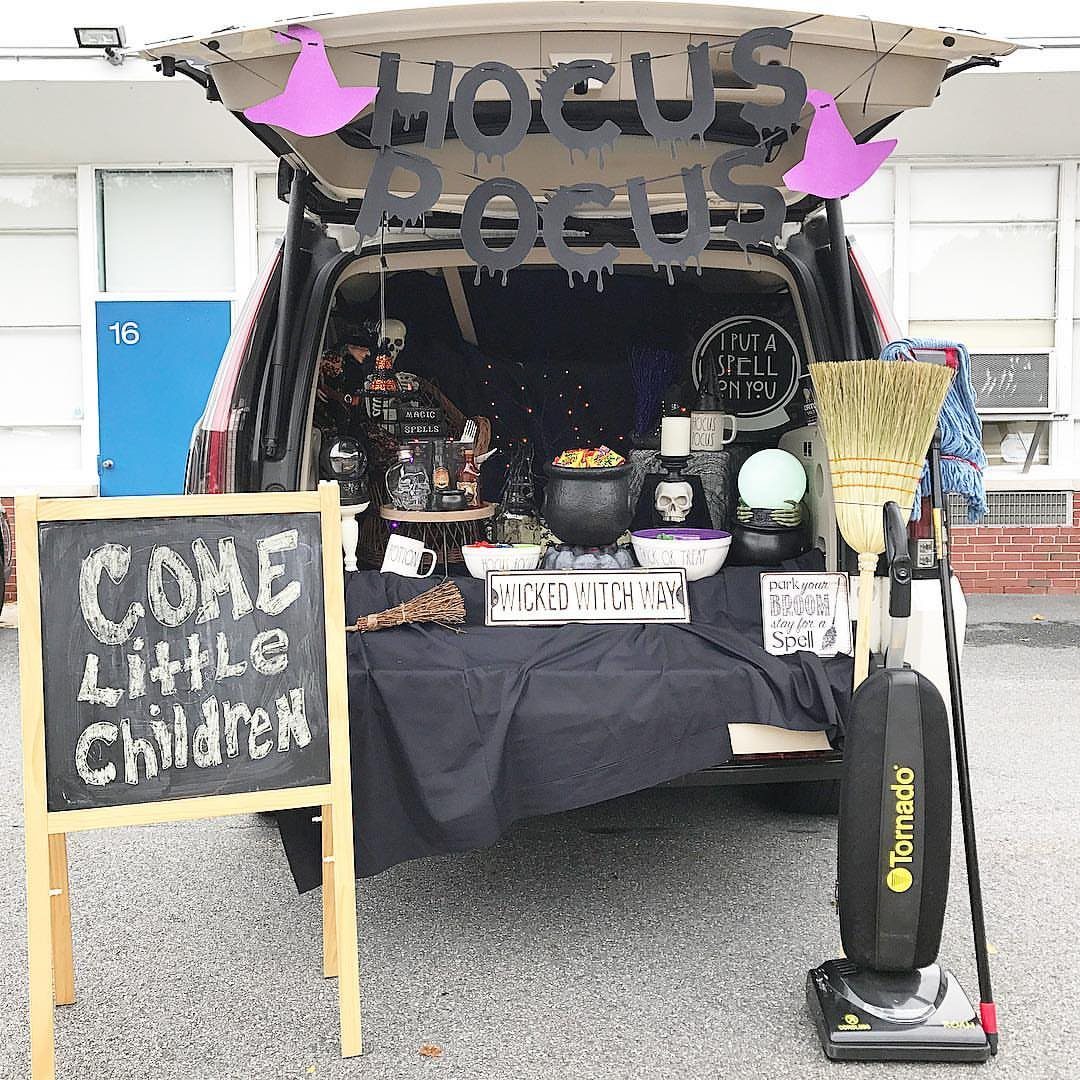 Hocus Pocus themed car trunk with cauldron, broom, and witch hat decorations.