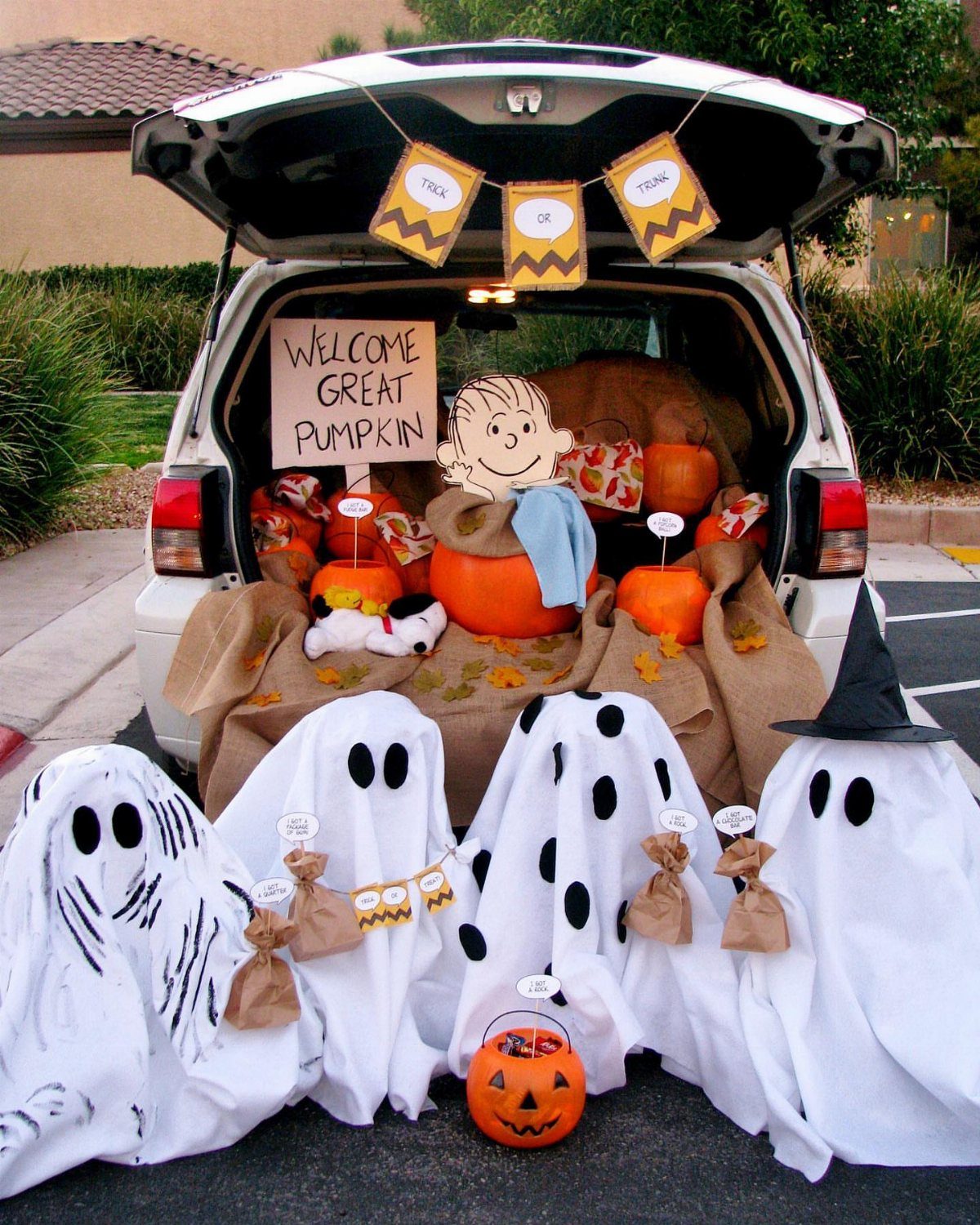 White SUV trunk decorated with pumpkins and Linus cutout for Great Pumpkin theme.