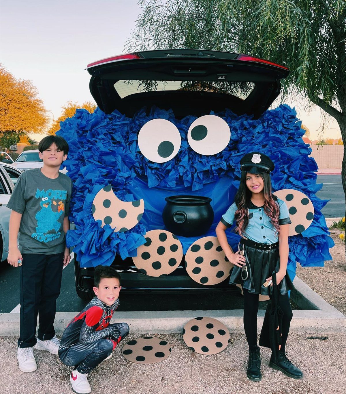 Blue furry monster car trunk decoration with large eyes and cardboard cookies.