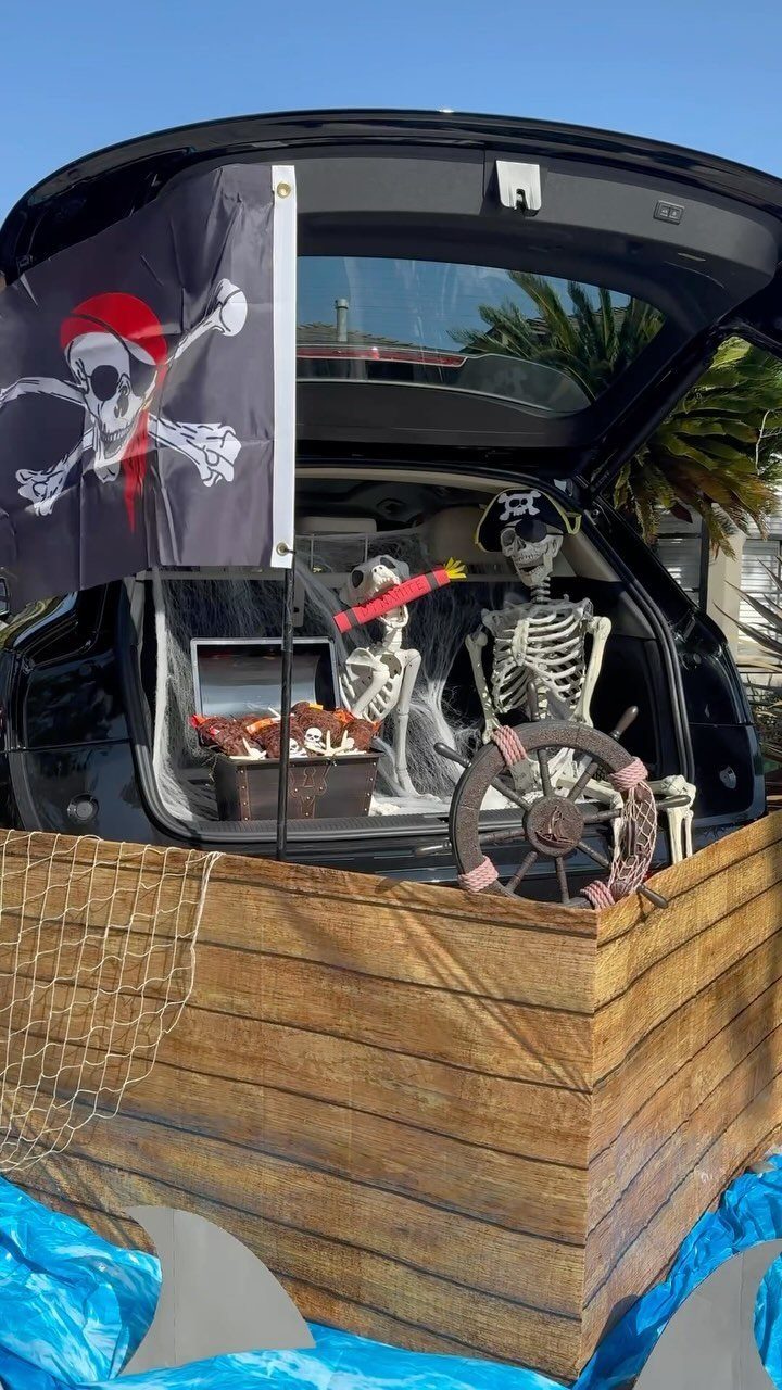 Pirate ship trunk or treat display with skeletons, treasure chest, and pirate flag.