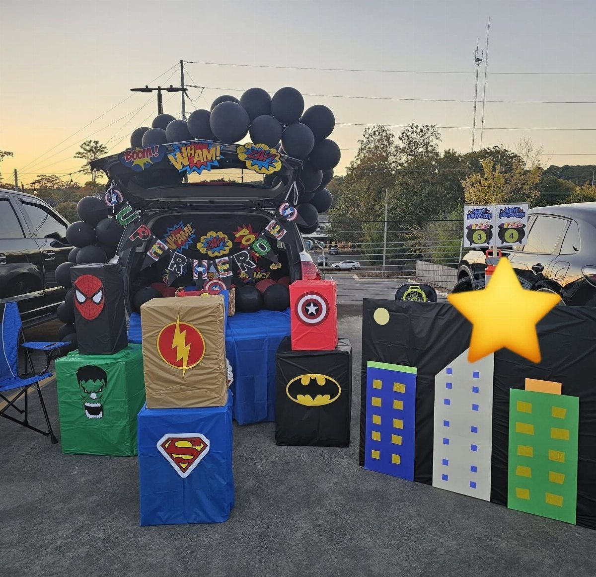 Superhero themed car trunk with comic book signs, character logo boxes, and cityscape.