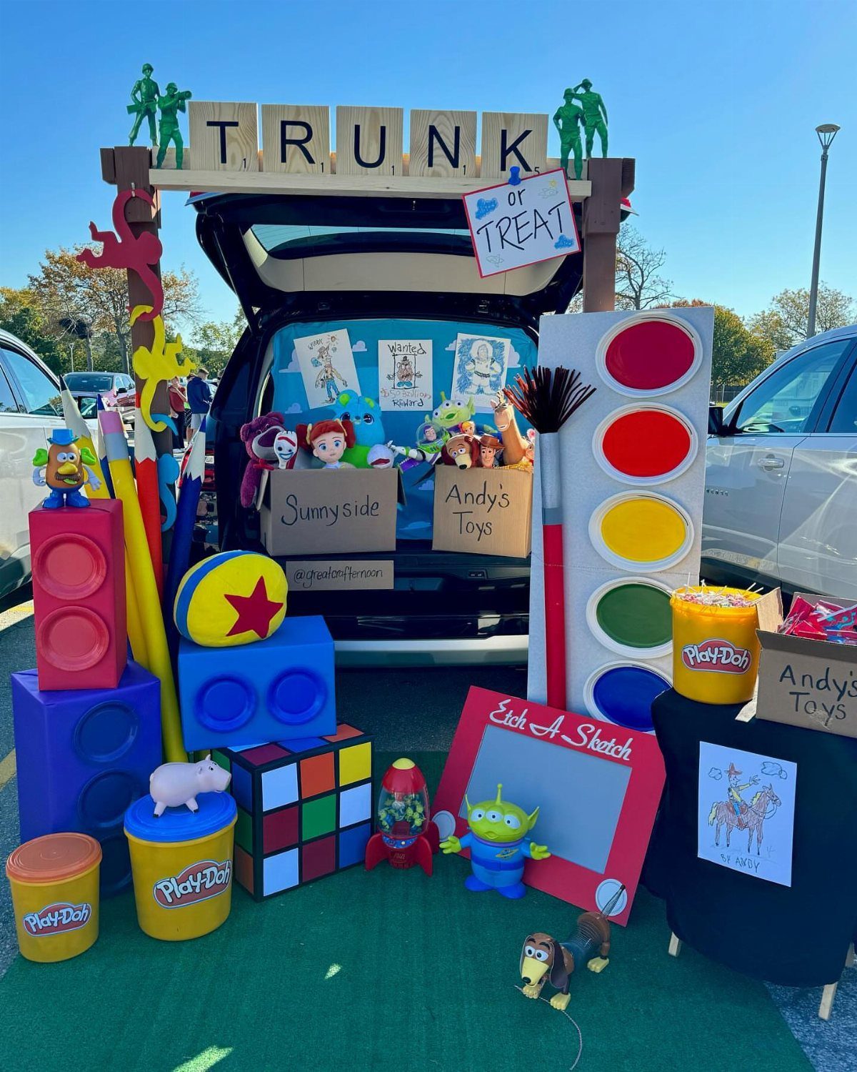 Toy Story themed car trunk display with giant toys and character figurines.
