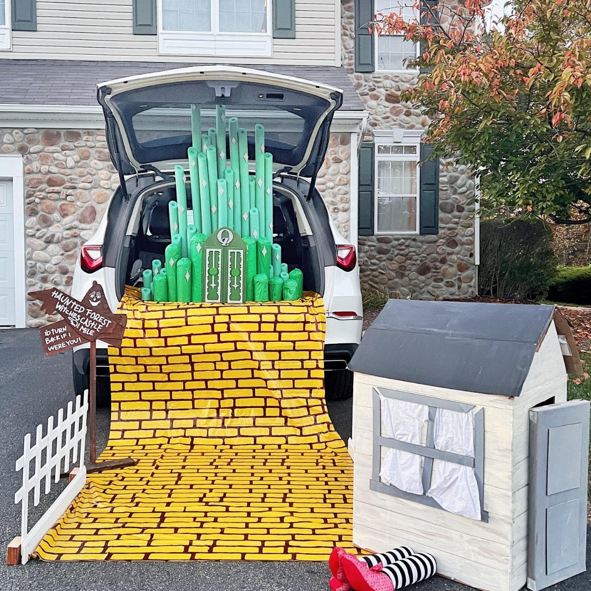 Emerald City trunk decoration with a yellow brick road leading to a small house.