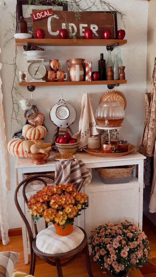 Rustic apple cider bar with copper mugs, pumpkins, and autumn floral arrangements.