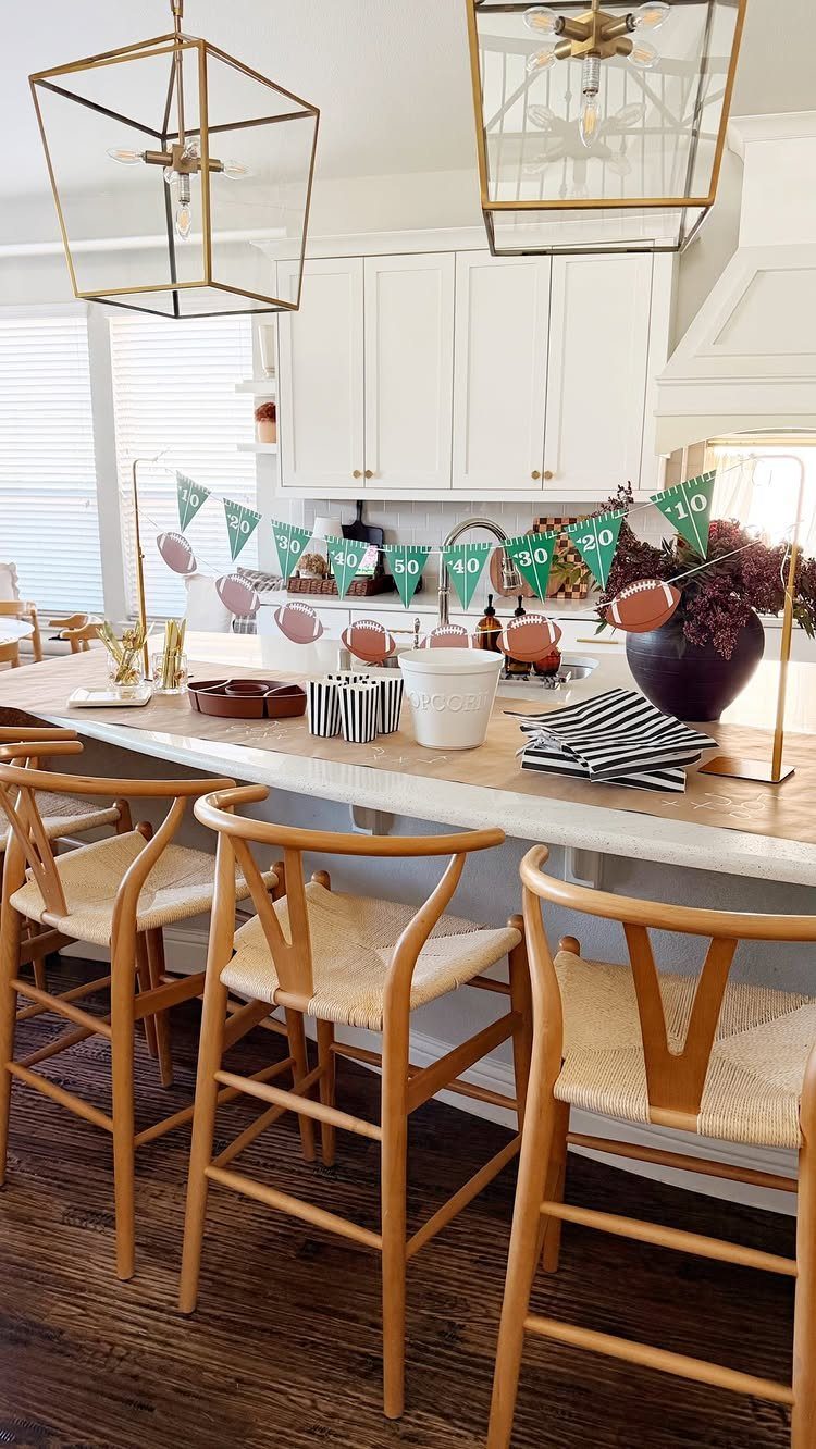 Kitchen island decorated for a football party with green banners and football cutouts.