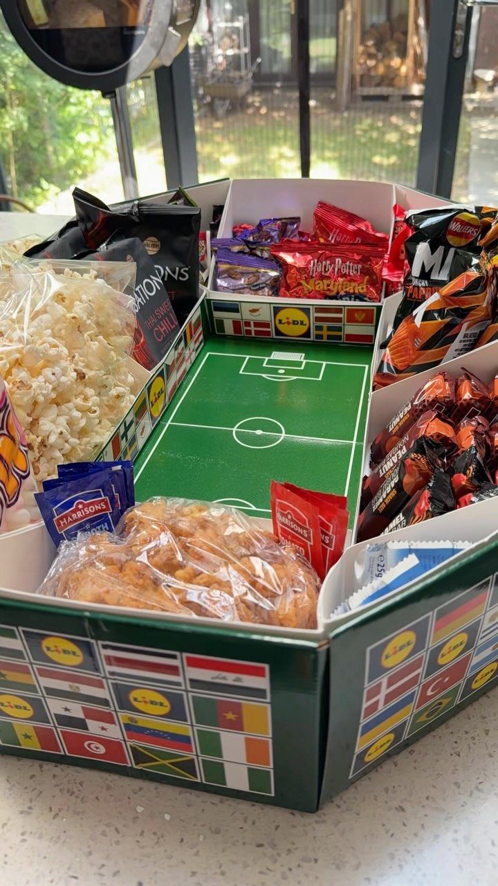 Snack tray with a football field center filled with various bagged party snacks