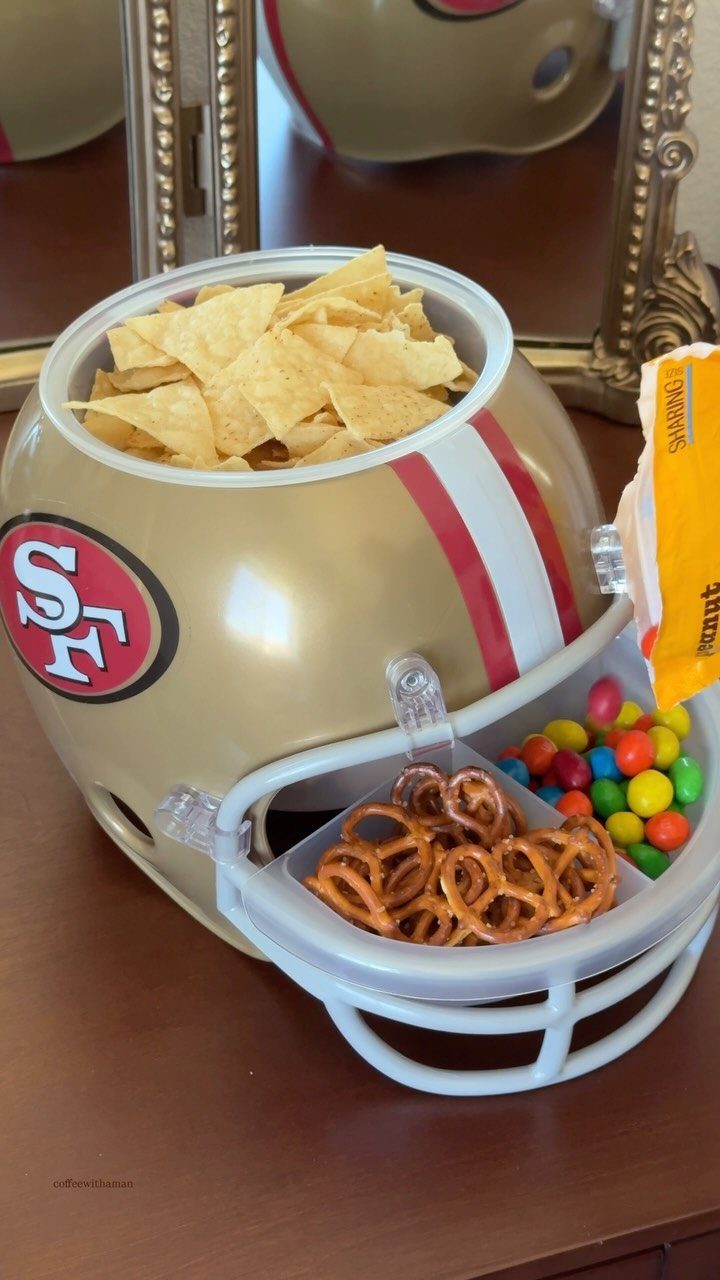 Gold football helmet snack bowl filled with chips, pretzels, and colorful candies.