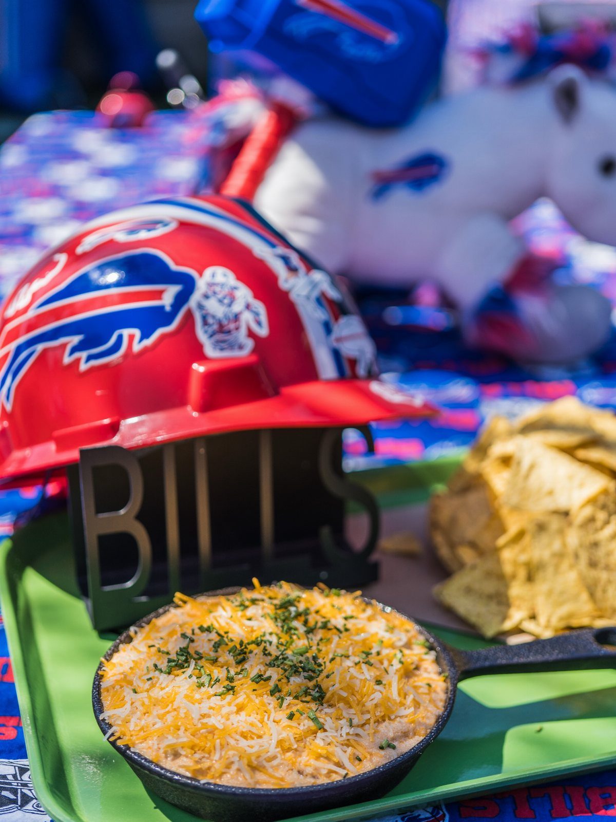 Creamy buffalo chicken dip in a skillet with chips and a Bills helmet.