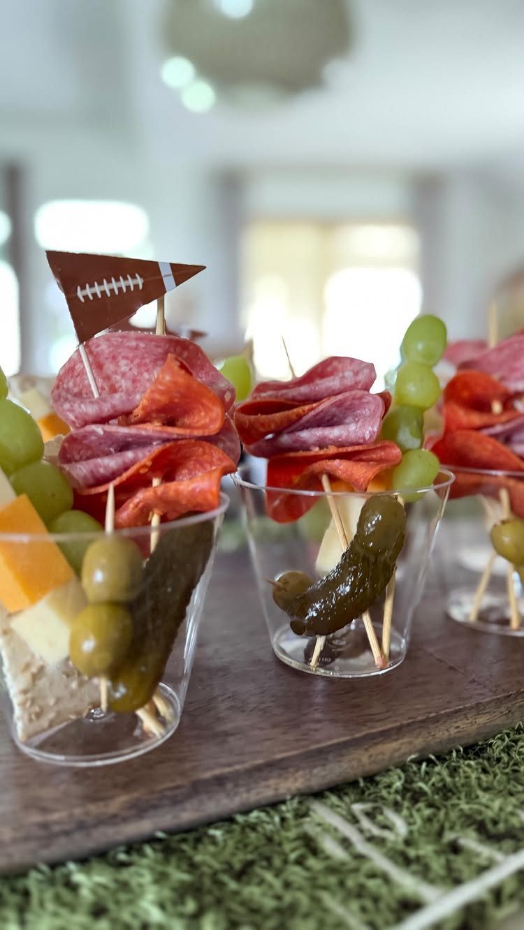 Appetizer skewers with salami and cheese in cups with a football flag