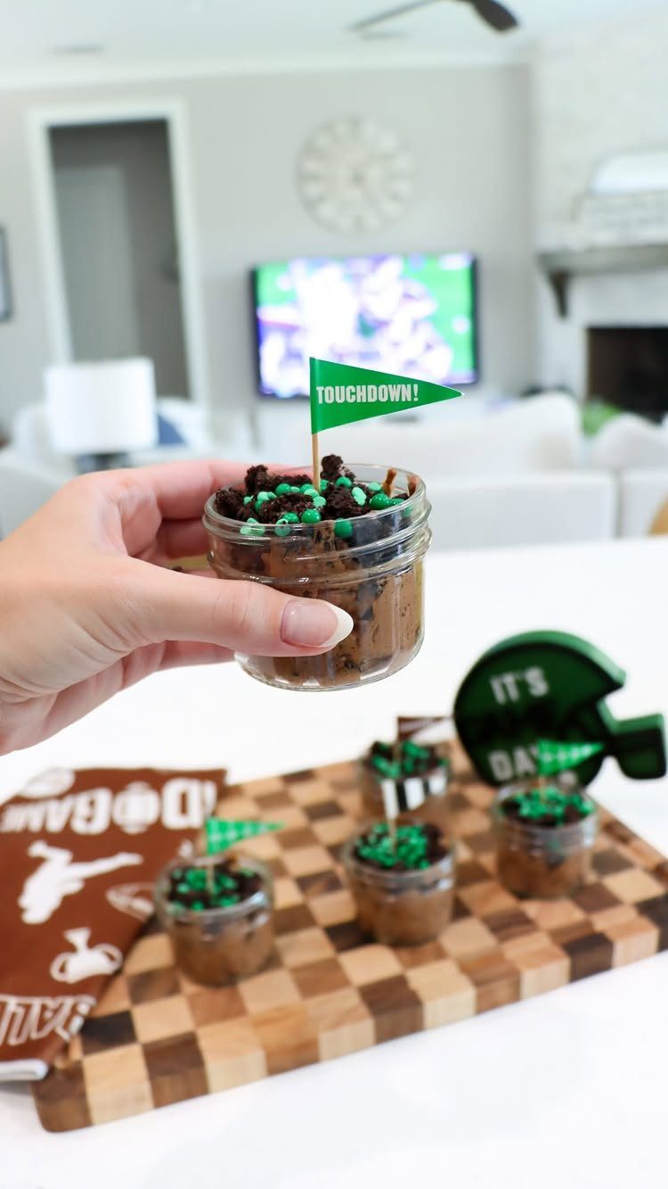 Chocolate dessert jars with touchdown flags on a wooden board for football party