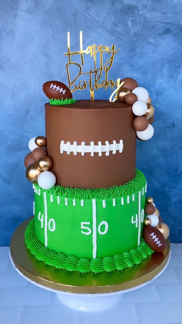 Two-tier football birthday cake with green field and brown football decorations