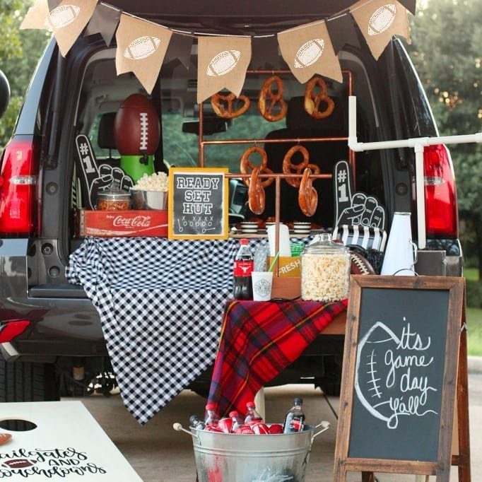 Football tailgate party setup in an SUV with snacks and game day decorations.