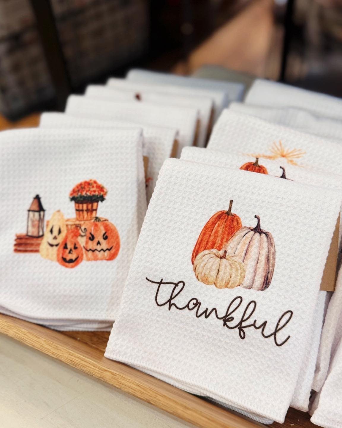 White waffle-weave kitchen towels with pumpkin illustrations and the word thankful.