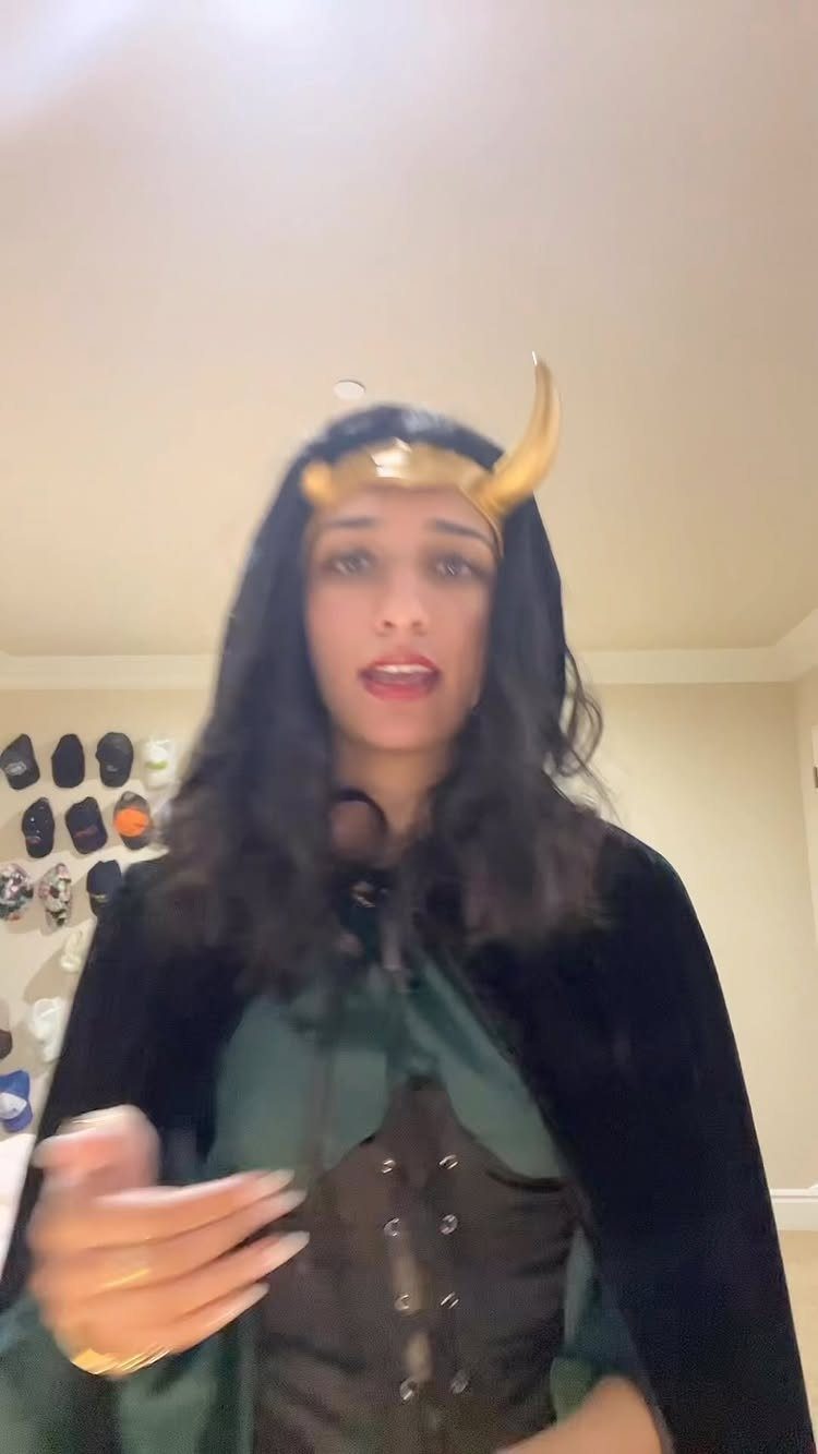 Woman wearing a green and brown costume with a gold horn headband.