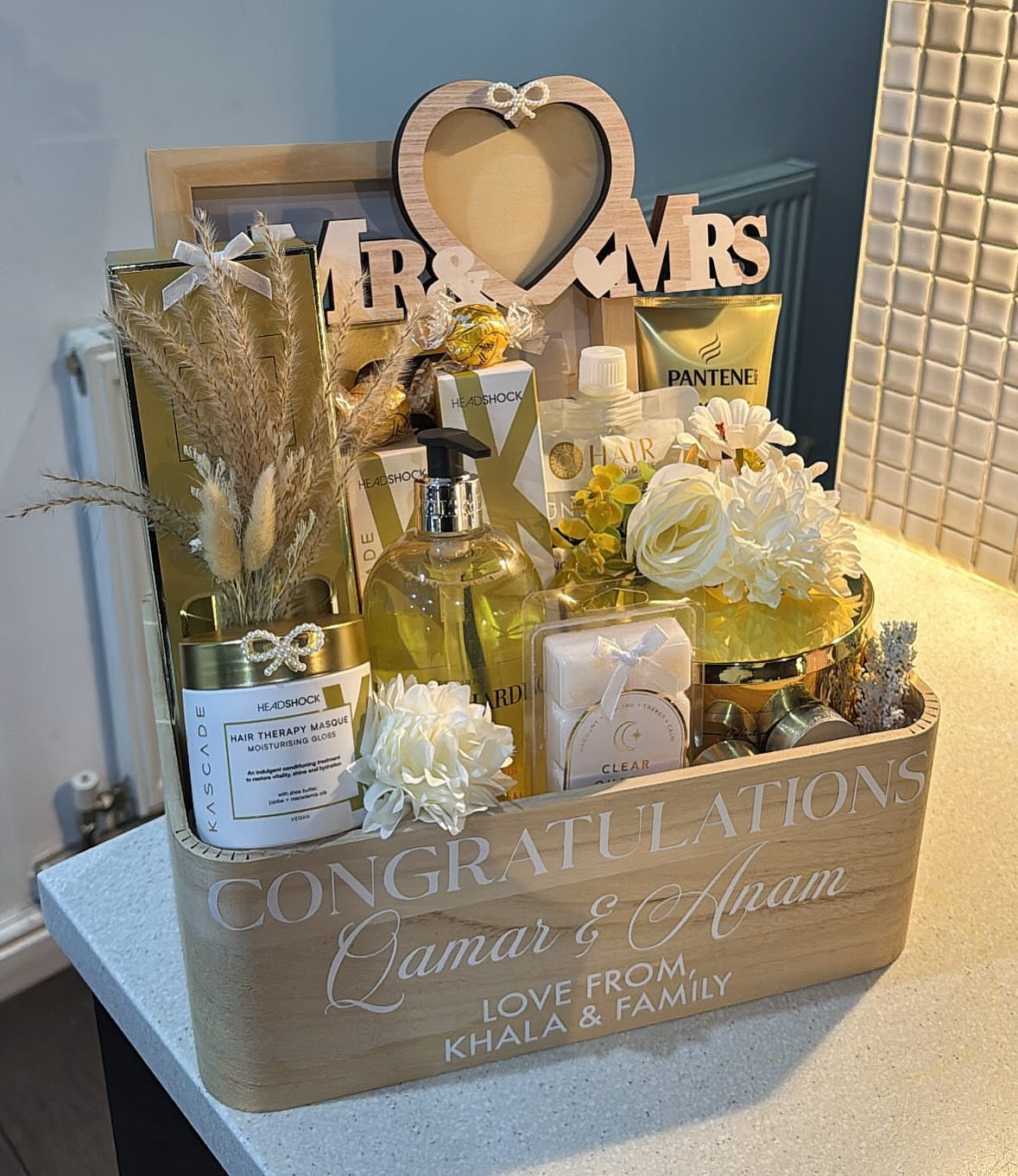 Wooden gift crate with yellow bath products, white flowers, and Mr and Mrs sign.