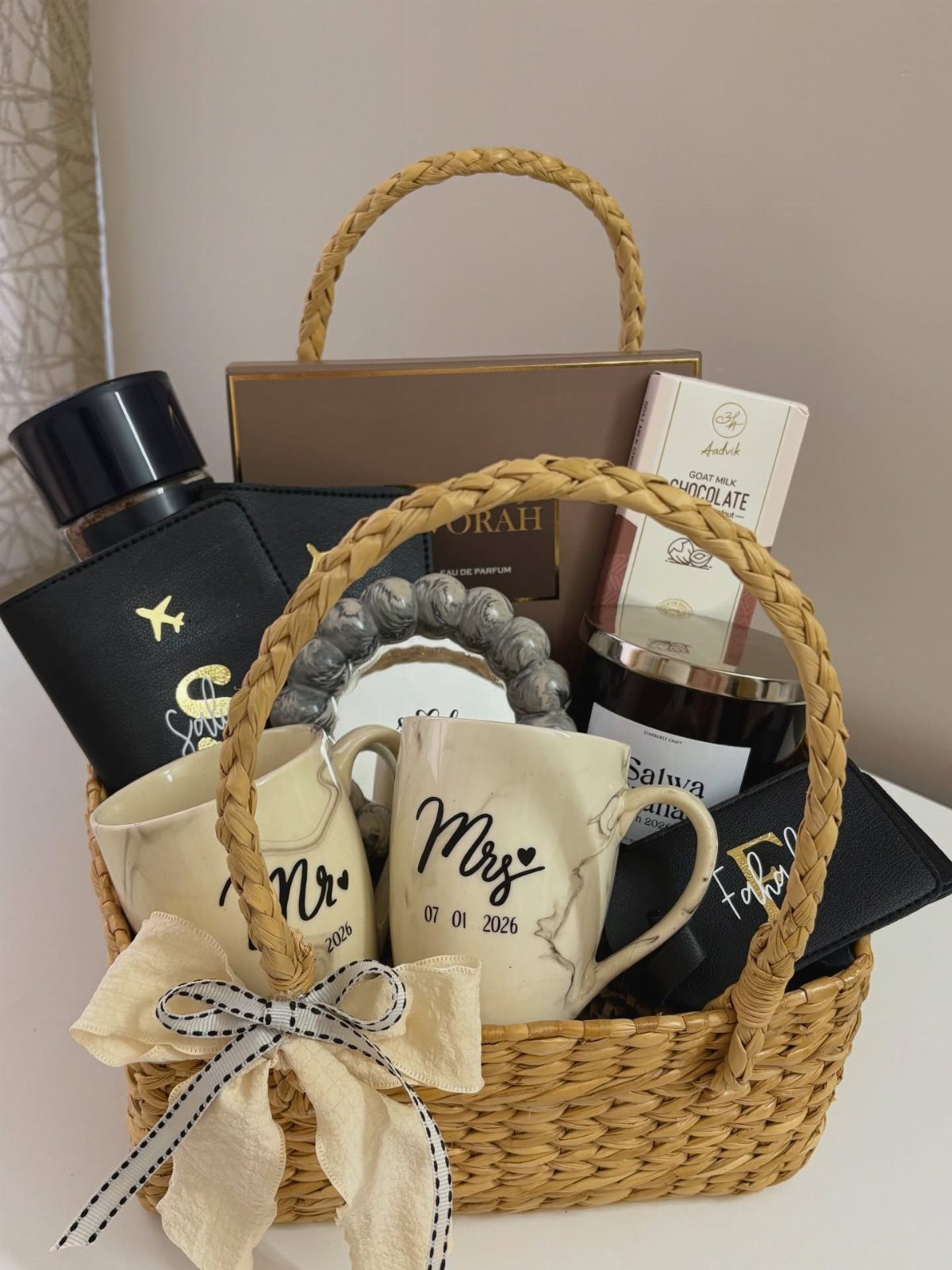 Woven gift basket with Mr and Mrs mugs, passport holder, and chocolate treats.