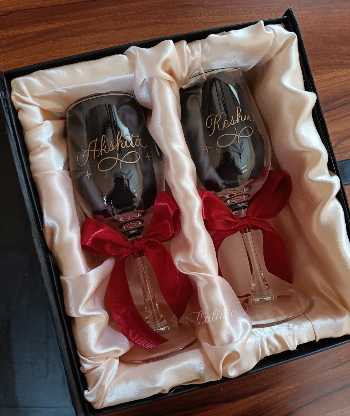 Engraved champagne flutes with red bows in a satin lined gift box