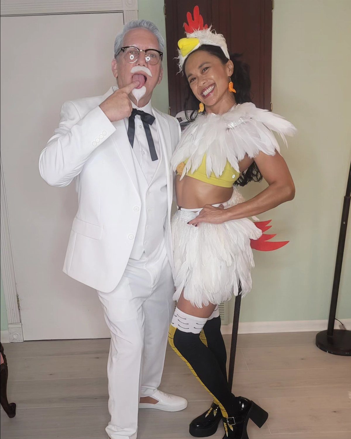 Man as Colonel Sanders and woman as a chicken posing together in costumes.