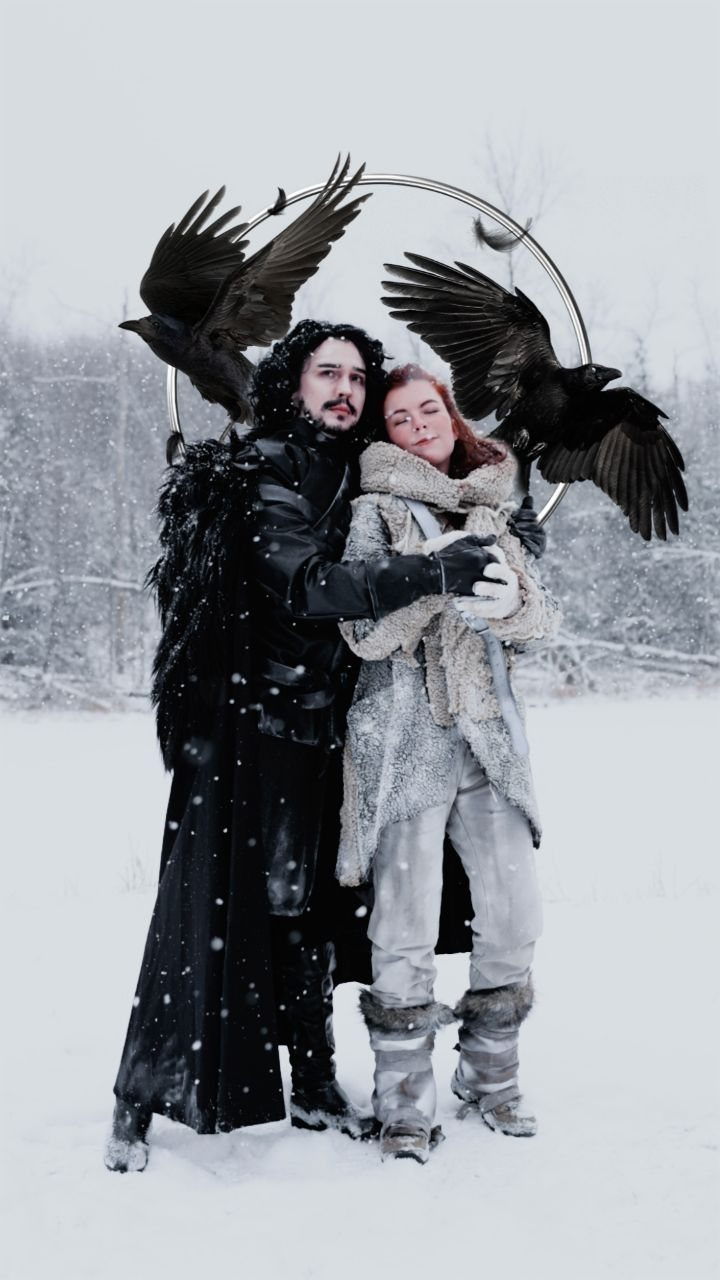 Man and woman in Game of Thrones costumes posing in a snowy field with crows.