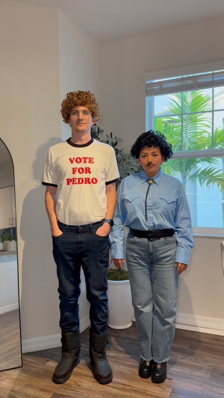 Two people dressed as Napoleon Dynamite and Pedro posing in a room.