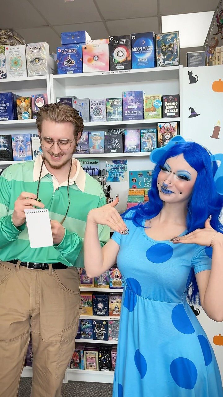 Man in green striped shirt and woman in blue polka-dot dress posing together.